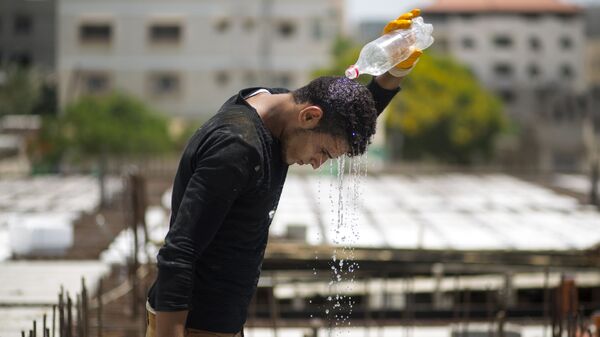 Мужчина обливает себя водой во время жаркой погоды, фото из архива - Sputnik Азербайджан