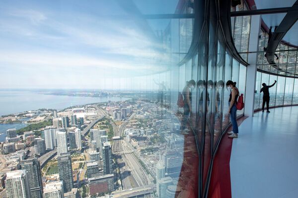 Люди смотрят на город из CN Tower в Торонто - Sputnik Азербайджан