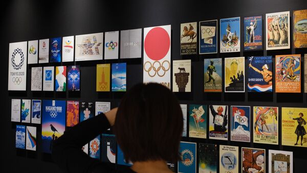 Посетитель фотографирует плакаты с предыдущих Олимпийских игр, выставленные в Японском Олимпийском музее в Токио, фото из архива - Sputnik Азербайджан
