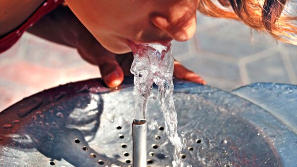 Девушка пьет холодную воду из питьевого фонтанчика - Sputnik Азербайджан