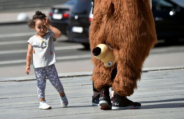 Девочка смотрит на уличного артиста в костюме медведя из мультфильма Маша и медведь в Киеве, Украина - Sputnik Азербайджан