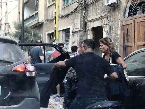 Люди, пострадавшие от осколков витрин, выбитых в результате взрыва в районе порта в Бейруте - Sputnik Азербайджан