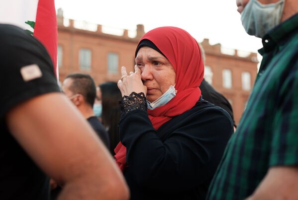 Женщина плачет на собрании в Тулузе, Франция, в поддержку пострадавших от взрыва в Бейруте - Sputnik Азербайджан