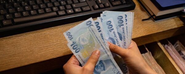 Сотрудник пункта обмена валюты считает банкноты турецких лир, фото из архива Сотрудник пункта обмена валюты считает банкноты турецких лир, фото из архива - Sputnik Азербайджан
