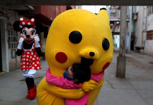 Волонтер в костюме Пикачу обнимает ребенка в Children's Day в Буэнос-Айресе - Sputnik Azərbaycan