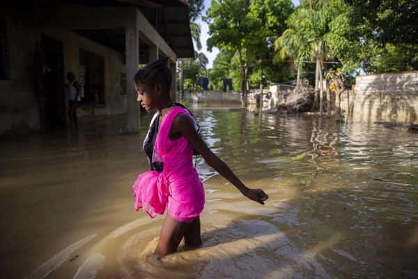 Девочка идет по затопленной после урагана улице на Гаити - Sputnik Азербайджан