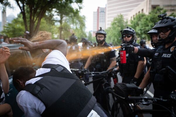 Полиция прыскает из газового балончика на протестанта во время беспорядков в Шарлотте, США - Sputnik Азербайджан
