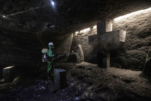 Рабочий дезинфицирует Соляной собор Сипакира, подземную церковь, встроенную в соляную шахту, Колумбия - Sputnik Азербайджан