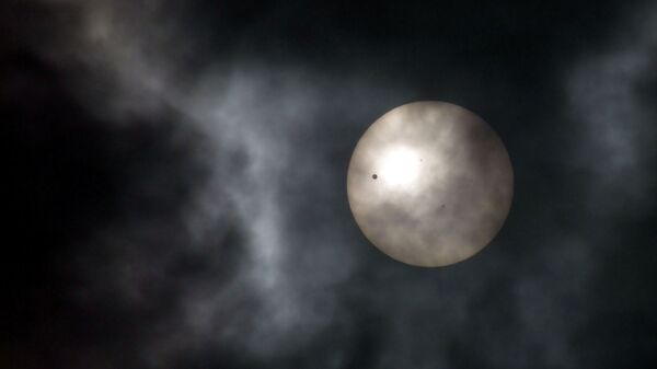 Венера (слева) в виде маленькой черной точки проходит через солнце, фото из архива - Sputnik Азербайджан