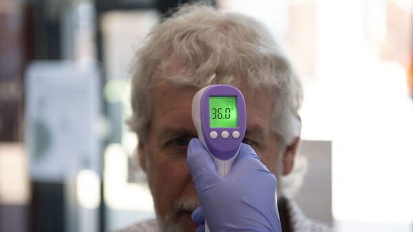 У пациента измеряют температуру с помощью инфракрасного термометра, фото из архива - Sputnik Azərbaycan