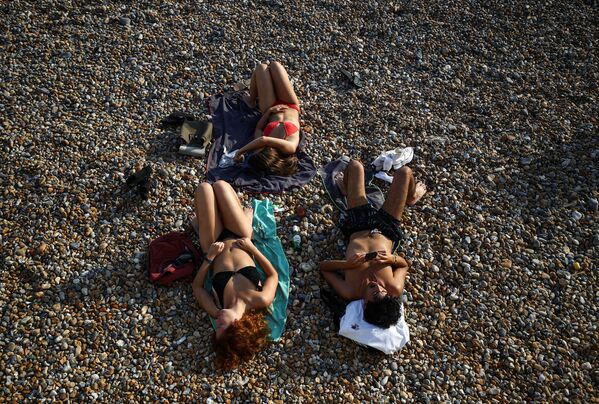 Отдыхающие на пляже в Брайтоне, Великобритания - Sputnik Азербайджан