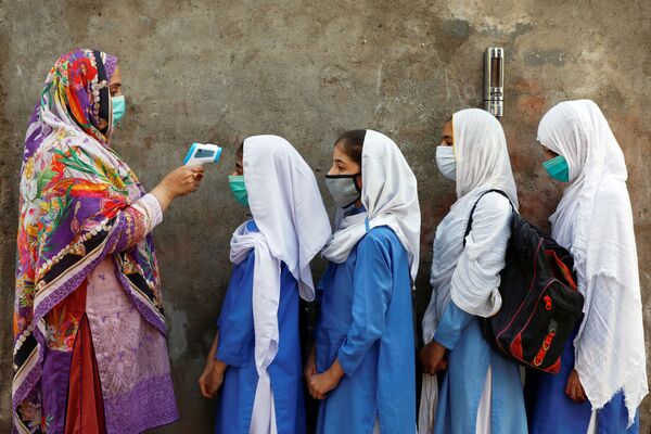 Проверка температуры у учеников перед входом в класс в Пешаваре, Пакистан - Sputnik Азербайджан