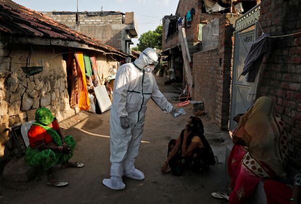 Темпы распространения коронавируса в Индии так растут, что скоро эта страна может выйти на первое место в мире по количеству зараженных. На фото - медицинские работники  проводят термоскрининг жителей бедных районов Индии - Sputnik Азербайджан