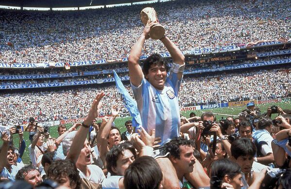 Диего Армандо Марадона поднимает над головой кубок мира по футболу после финального матча против сборной ФРГ, 1986-й год. - Sputnik Азербайджан