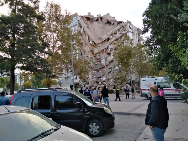 Местные жители и официальные лица ищут выживших в обрушившемся здании после сильного землетрясения в Измире  - Sputnik Azərbaycan