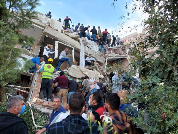  Местные жители и официальные лица ищут выживших в обрушившемся здании после сильного землетрясения в Измире  - Sputnik Азербайджан