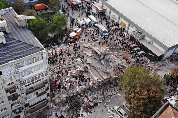 Местные жители и официальные лица ищут выживших в обрушившемся здании после сильного землетрясения в Измире - Sputnik Azərbaycan