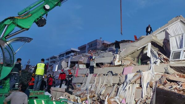 Местные жители и официальные лица ищут выживших в обрушившемся здании после сильного землетрясения в Измире  - Sputnik Azərbaycan