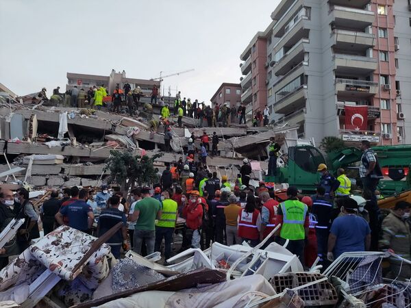 Местные жители и официальные лица ищут выживших в обрушившемся здании после сильного землетрясения в Измире  - Sputnik Азербайджан
