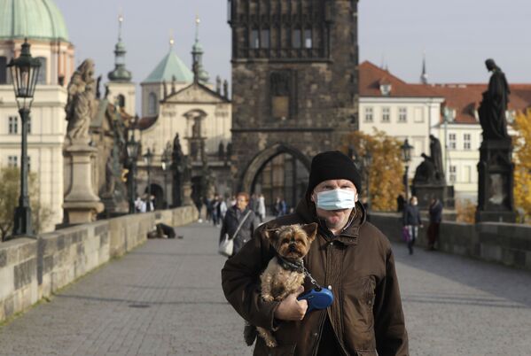 Мужчина в защитной медицинской маске на Карловом мосту в Праге, Чехия - Sputnik Азербайджан