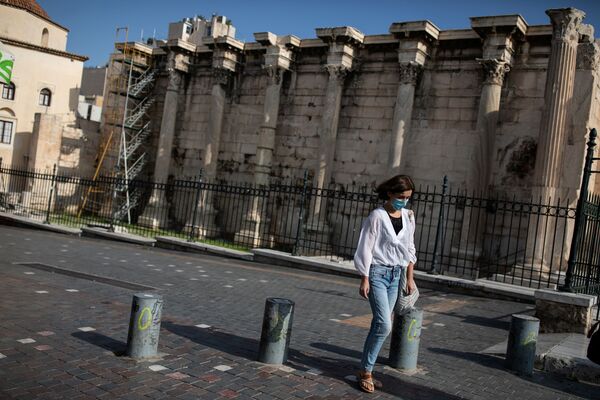 Девушка в защитной маске проходит мимо места археологических раскопок в Библиотеке Адриана во время локдауна, объявленного правительством в связи с коронавирусом, в Афинах, Греция - Sputnik Azərbaycan