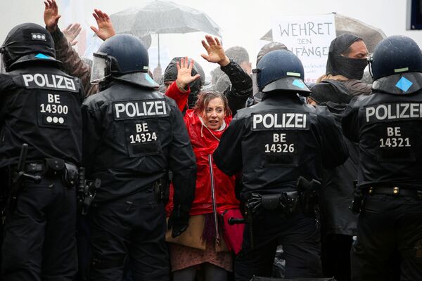 Демонстранты перед полицейскими во время акции протеста против правительственных ограничений, связанных с коронавирусом, возле Бранденбургских ворот в Берлине - Sputnik Азербайджан