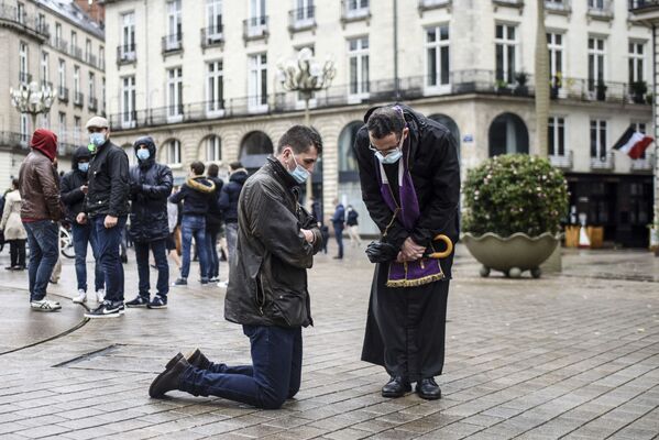 Католический священник исповедует верующего на улице в Нанте, Франция - Sputnik Азербайджан