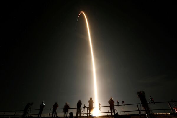 Люди наблюдают за запуском ракеты SpaceX Falcon 9 с капсулой Crew Dragon с четырьмя астронавтами в Космическом центре Кеннеди на мысе Канаверал, Флорида, США - Sputnik Азербайджан