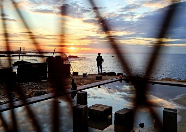 Рыбак на набережной в столице Ливии Триполи. - Sputnik Азербайджан