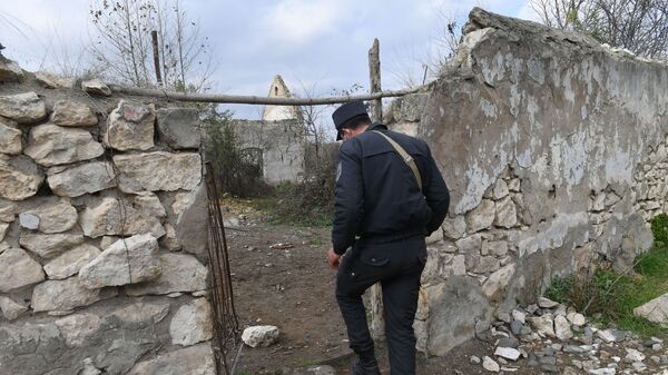 Азербайджанский полицейский у разрушенных домов в Карабахе, фото из архива - Sputnik Азербайджан
