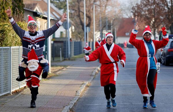 Люди в костюмах Санта-Клаусов во время забега Святого Николая в Берлине, Германия - Sputnik Азербайджан