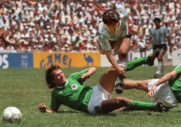 Диего Марадона уклоняется от подката Лотара Маттауса во время финала чемпионата мира по футболу 1986 года - Sputnik Azərbaycan