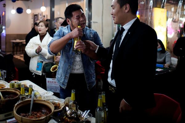 Мужчина открывает пиво зубами в одном из ресторанов Уханя - Sputnik Азербайджан