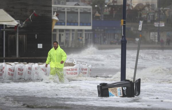 Мужчина на затопленной набережной города Суонедж, Великобритания  - Sputnik Azərbaycan
