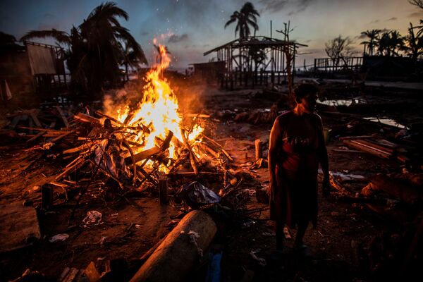 Люди сжигают мусор, оставшийся после урагана Йота в Бильви, Никарагуа - Sputnik Azərbaycan