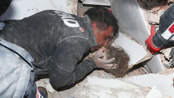 Турецкие спасатели вытаскивают ребенка из под обломков после землетрясения в Измире - Sputnik Azərbaycan