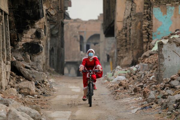 Девушка в костюме Санта-Клауса едет по улице Мосула, Ирак - Sputnik Азербайджан