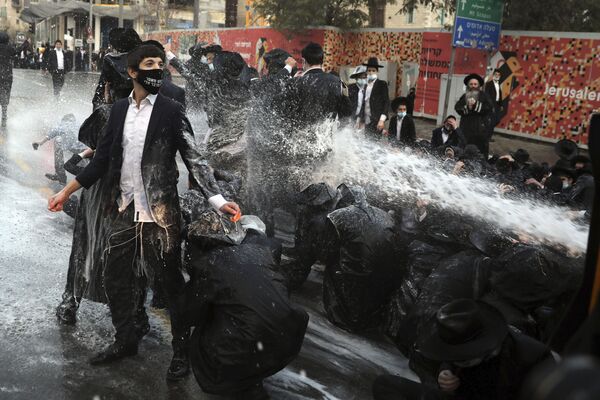 Израильская полиция стреляет из водомета по ультраортодоксам, блокирующим дорогу во время демонстрации в Иерусалиме - Sputnik Азербайджан