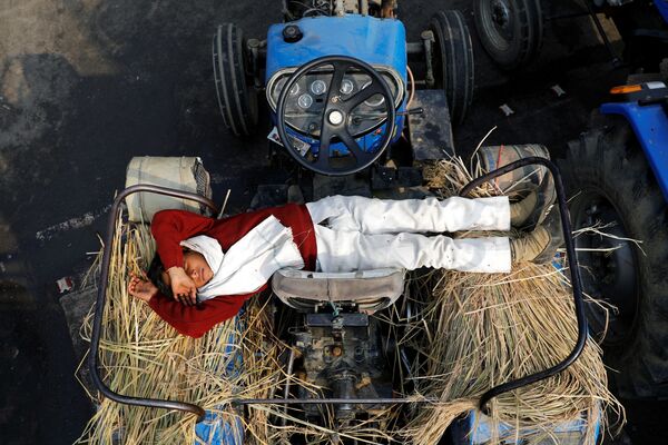 Сын фермера спит в тракторе во время протеста против новых фермерских законов на границе Дели и Уттар Прадеш, Индия - Sputnik Азербайджан