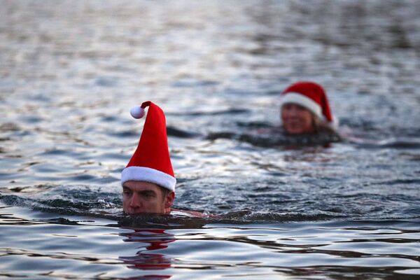 Люди в рождественских колпаках плаваю в озере Серпентин в Гайд-парке в Лондоне - Sputnik Azərbaycan