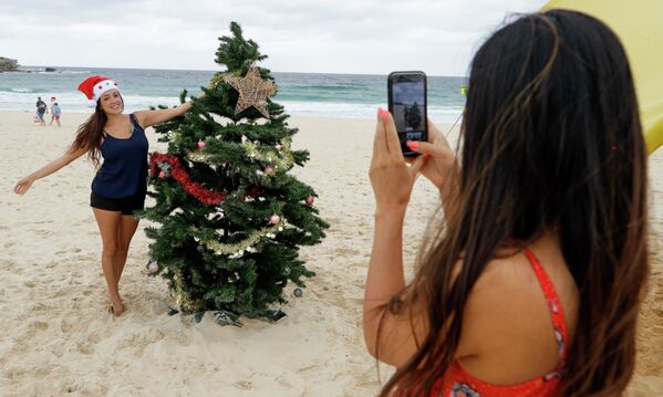 Девушки фотографируются у рождественской ели на пляже в Сиднее, Австралия  - Sputnik Azərbaycan