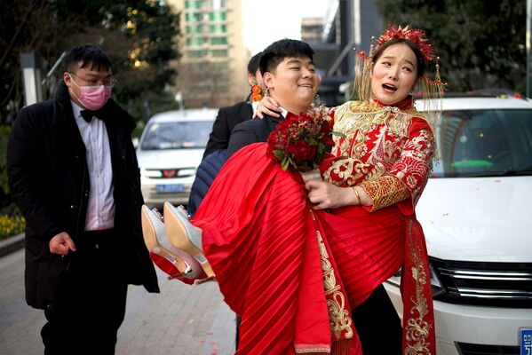 Жених несет невесту в отель после их новогодней свадьбы в Ухане, Китай - Sputnik Азербайджан