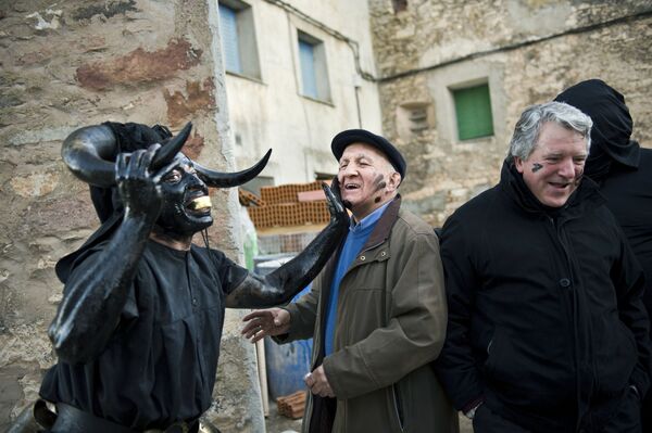 Мужчина с бычьими рогами и в нефти и саже во время карнавала в Испании  - Sputnik Azərbaycan