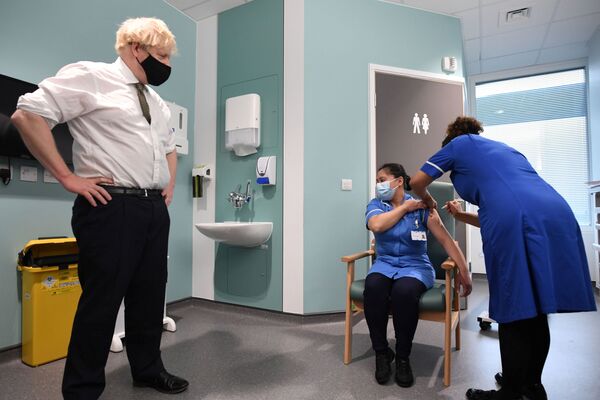 Премьер-министр Великобритании Борис Джонсон наблюдает за вакцинацией во время своего визита в больницу Chase Farm на севере Лондона - Sputnik Azərbaycan