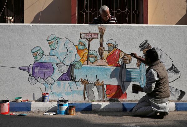 Мужчина рисует граффити, изображающее вакцину от COVID-19, в Калькутте, Индия - Sputnik Азербайджан
