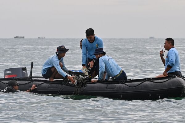 Водолазы ВМС Индонезии собирают обломки рейса Sriwijaya Air SJY182 во время поисково-спасательной операции в море недалеко от острова Ланканг  - Sputnik Азербайджан