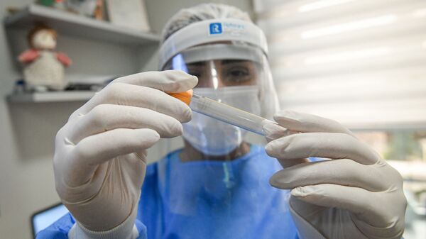 Лаборантка показывает тест на коронавирус в одной из бакинских клиник - Sputnik Азербайджан