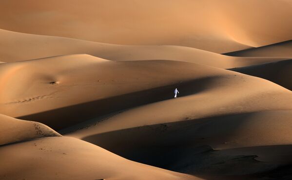 Человек в песчаных дюнах в пустыне Лива, ОАЭ - Sputnik Azərbaycan