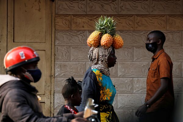 Женщина несет ананасы на голове в Кампале, Уганда - Sputnik Azərbaycan