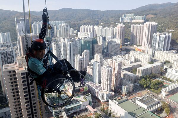 Альпинист Lai Chi-wai с параличом нижних конечностей, пытается подняться на башню Nina в Гонконге - Sputnik Азербайджан